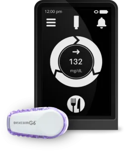 Dexcom G6 and receiver screen displaying glucose level.