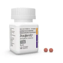 Tradjenta 5mg (linagliptin tablets) medicine bottle with two reddish-brown pills.