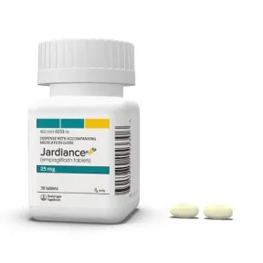 Jardiance 25 mg medication bottle with two light yellow oval pills next to it.