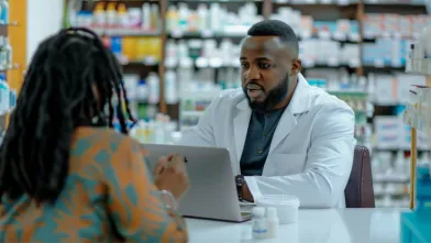 A pharmacist helps discuss health care cost options