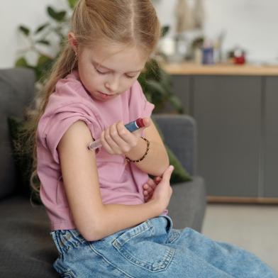 girl injecting insulin in arm