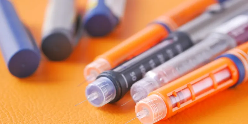 Close-up of insulin injection pens and needles.