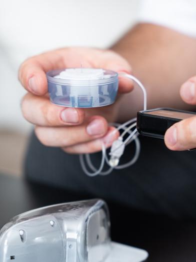Man holding an infusion set for delivering insulin from an insulin pump