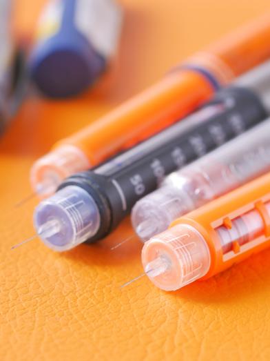 Close-up of insulin injection pens and needles.