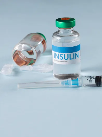 insulin vial and syringe on a light blue background